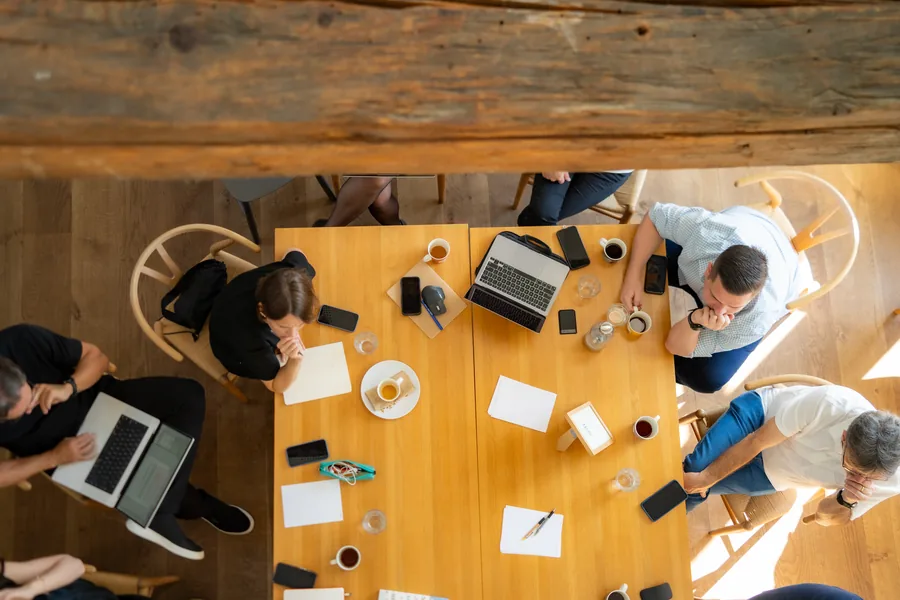 Vista superior de uma mesa de trabalho com notebooks e anotações